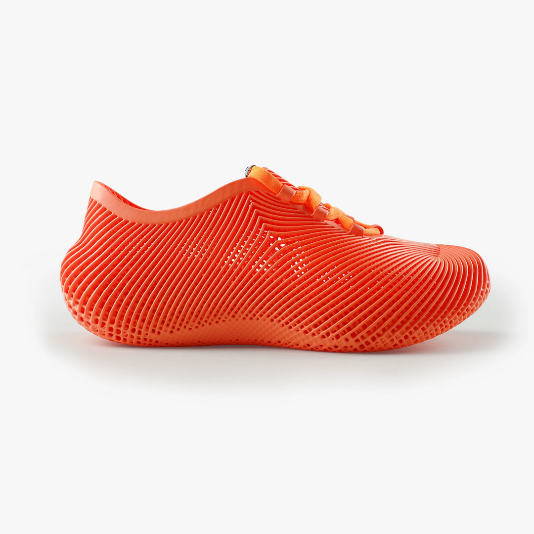 Side view of orange 3D printed sneakers textured upper