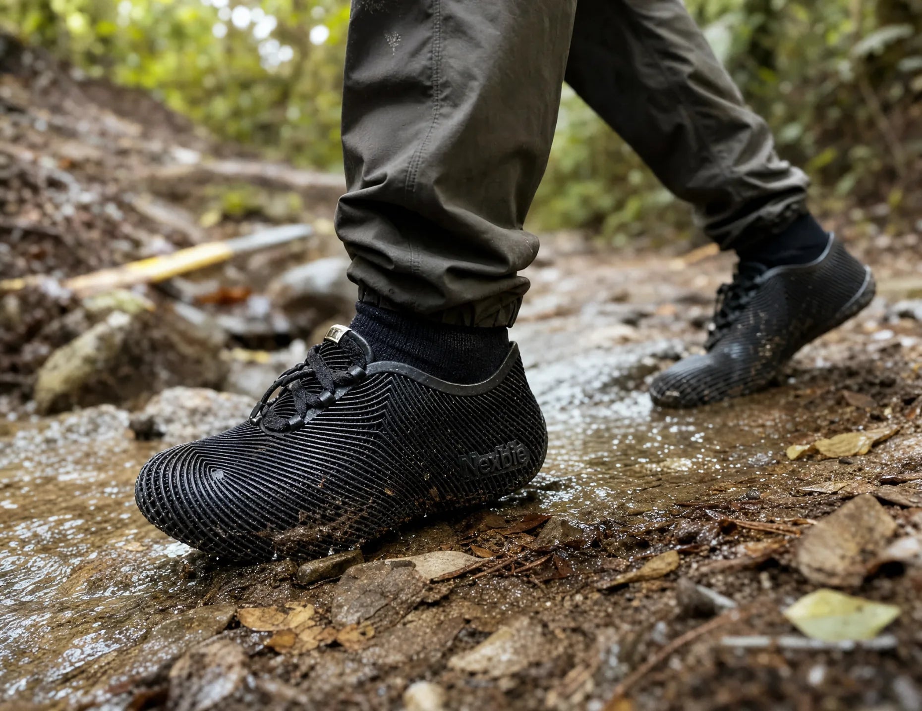 Person hiking along a muddy forest trail in Aeroraise sneakers